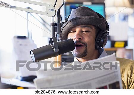 Mixed race disc jockey talking into mic in studio View Large Photo Image Stock Photograph - Mixed race disc jockey talking into mic in studio. Fotosearch
