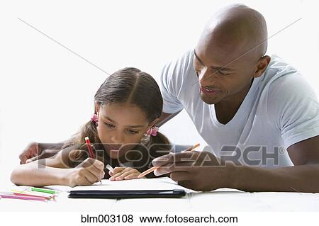 Stock Photo - Mixed race father helping daughter with homework. Fotosearch