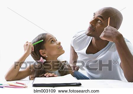 Mixed race father helping daughter with homework View Large Photo Image Stock Photo - Mixed race father helping daughter with homework. Fotosearch