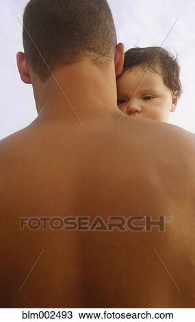 Stock Image - Mixed Race father holding baby. Fotosearch