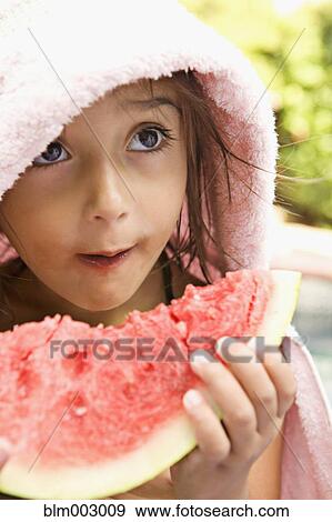 Stock Photo - Mixed race girl enjoying slice of watermelon. Fotosearch