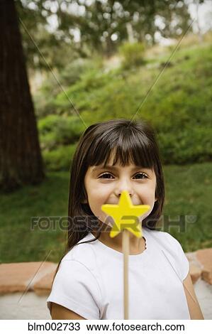 Stock Image - Mixed race girl holding star wand. Fotosearch