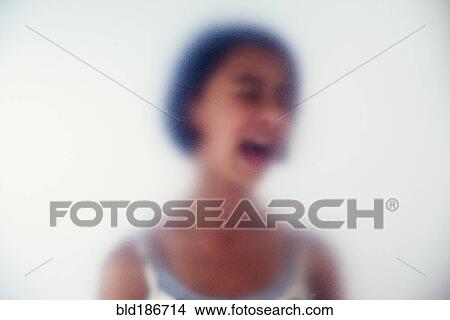 Picture - Mixed race girl shouting behind frosted glass. Fotosearch