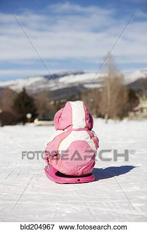 Mixed race girl sledding in snow View Large Photo Image Stock Photo - Mixed race girl sledding in snow. Fotosearch