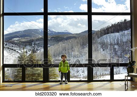 Stock Image - Mixed race girl standing in ski lodge. Fotosearch