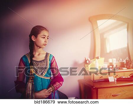 Stock Photo - Mixed race girl wearing Indian dress in bedroom. Fotosearch