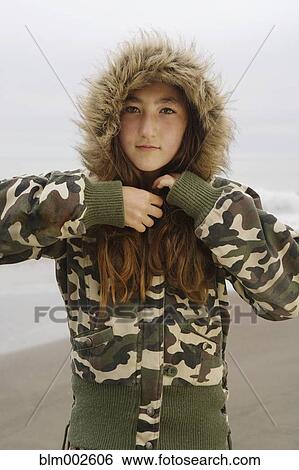 Stock Photograph - Mixed Race girl wearing jacket at beach. Fotosearch