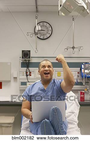 Stock Image - Mixed Race male medical professional raising fist. Fotosearch