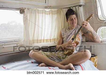 Mixed race man playing ukulele View Large Photo Image Stock Image - Mixed race man playing ukulele. Fotosearch