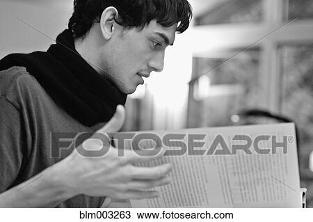 Stock Image - Mixed race man reading book. Fotosearch