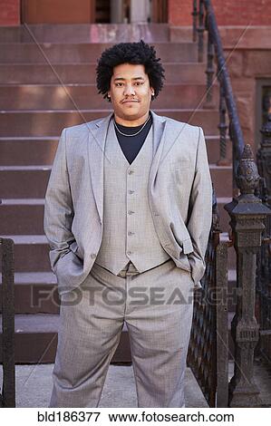Stock Photo - Mixed race man standing near front stoop. Fotosearch