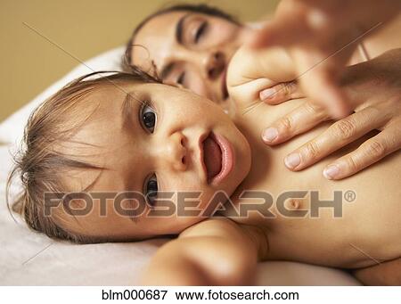 Stock Photo - Mixed race mother and son laying on bed. Fotosearch