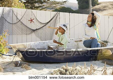 Mixed race mother and son pretending to sail in a boat View Large Photo Image Picture - Mixed race mother and son pretending to sail in a boat. Fotosearch