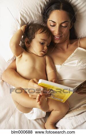 Stock Photo - Mixed race mother reading story book to son. Fotosearch