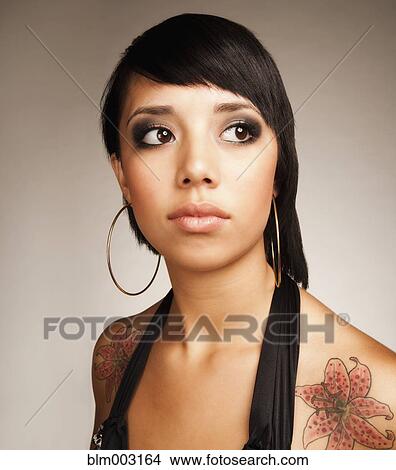 Picture - Mixed race teenage girl with flower tattoos. Fotosearch