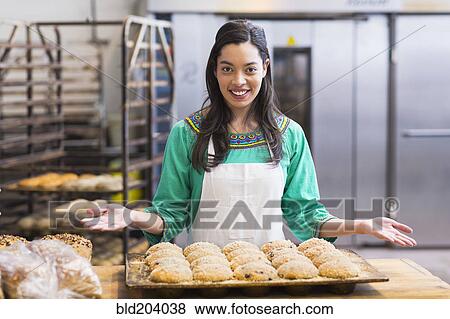Mixed race woman baking in industrial kitchen View Large Photo Image Stock Photo - Mixed race woman baking in industrial kitchen. Fotosearch