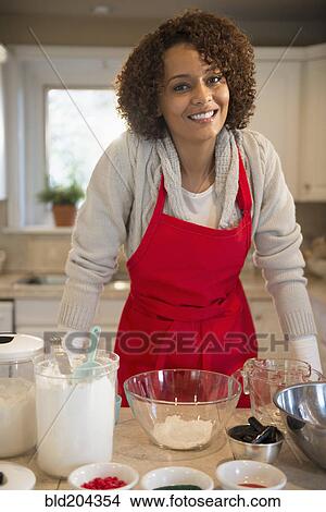 Mixed race woman baking in kitchen View Large Photo Image Picture - Mixed race woman baking in kitchen. Fotosearch