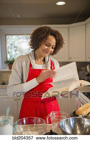 Stock Photo - Mixed race woman baking in kitchen. Fotosearch