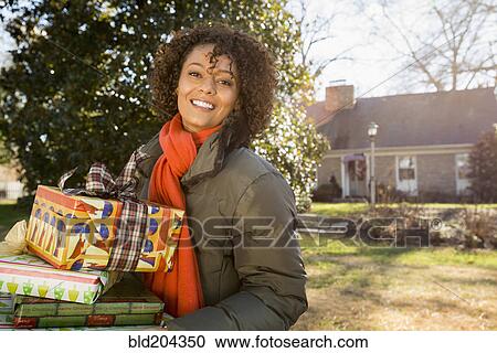 Mixed race woman carrying Christmas gifts View Large Photo Image Stock Image - Mixed race woman carrying Christmas gifts. Fotosearch