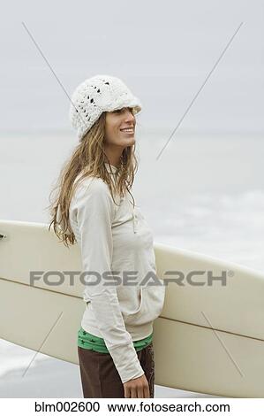 Mixed race woman holding surfboard View Large Photo Image Stock Image - Mixed race woman holding surfboard. Fotosearch