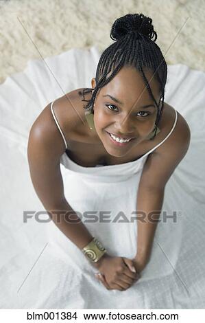 Picture - Mixed race woman in white dress looking up. Fotosearch