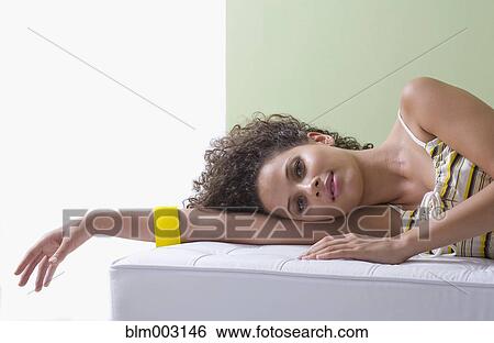 Mixed race woman laying on sofa View Large Photo Image Stock Photograph - Mixed race woman laying on sofa. Fotosearch