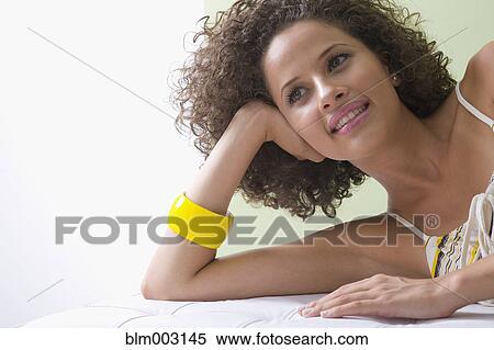 Mixed race woman laying on sofa View Large Photo Image Stock Photography - Mixed race woman laying on sofa. Fotosearch