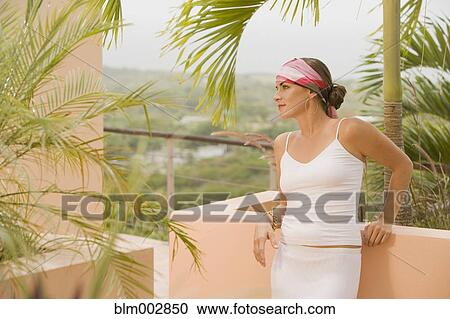 Mixed race woman leaning against balcony wall View Large Photo Image Stock Image - Mixed race woman leaning against balcony wall. Fotosearch