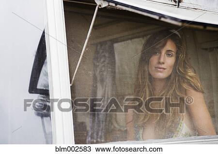 Stock Image - Mixed race woman looking through screen. Fotosearch