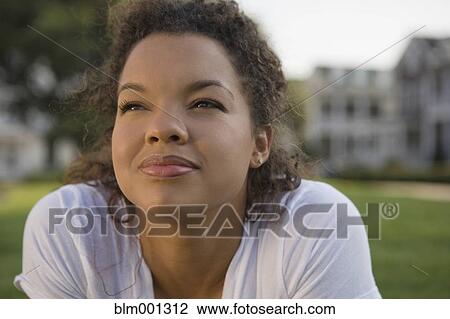 Mixed race woman looking up outdoors View Large Photo Image Stock Image - Mixed race woman looking up outdoors. Fotosearch