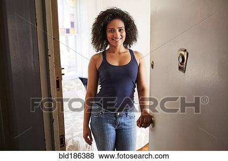 Mixed race woman opening apartment door View Large Photo Image Stock Photo - Mixed race woman opening apartment door. Fotosearch