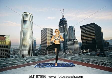 Mixed race woman practicing yoga on urban rooftop View Large Photo Image Stock Photograph - Mixed race woman practicing yoga on urban rooftop. Fotosearch