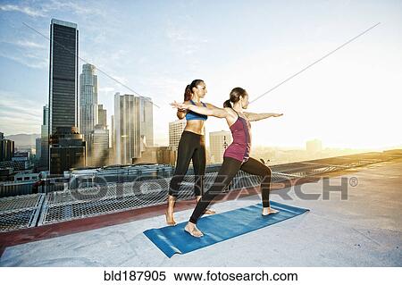 Stock Photography - Mixed race woman practicing yoga on urban rooftop. Fotosearch