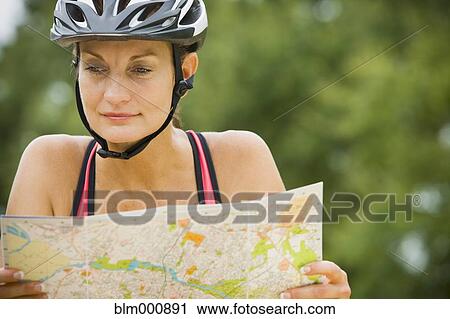 Stock Image - Mixed race woman riding bicycle. Fotosearch