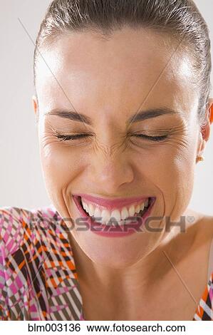 Mixed race woman smiling and grimacing with eyes closed View Large Photo Image Stock Photograph - Mixed race woman smiling and grimacing with eyes closed. Fotosearch