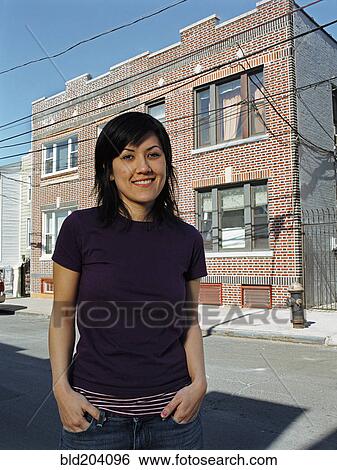 Stock Photograph - Mixed race woman smiling on city street. Fotosearch