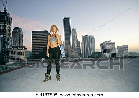 Mixed race woman standing on urban rooftop View Large Photo Image Stock Photography - Mixed race woman standing on urban rooftop. Fotosearch