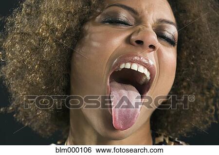 Stock Photograph - Mixed Race woman sticking out tongue. Fotosearch
