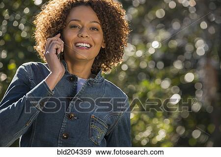 Mixed race woman talking on cell phone View Large Photo Image Stock Photo - Mixed race woman talking on cell phone. Fotosearch