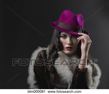 Stock Image - Mixed Race woman wearing hat and fur coat. Fotosearch