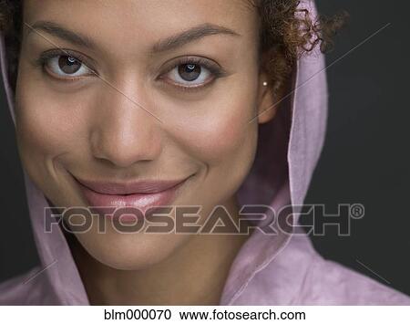 Stock Image - Mixed Race woman wearing hooded shirt. Fotosearch
