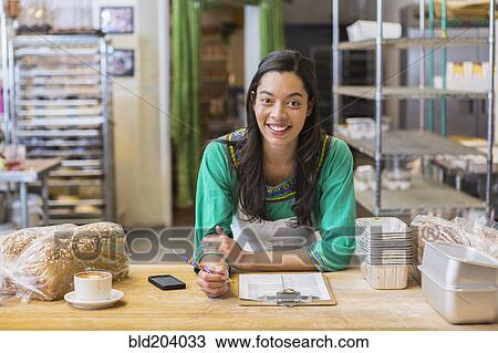 Mixed race woman working in bakery kitchen View Large Photo Image Stock Image - Mixed race woman working in bakery kitchen. Fotosearch