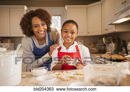 Stock Image - Mother and daughter baking in kitchen. Fotosearch