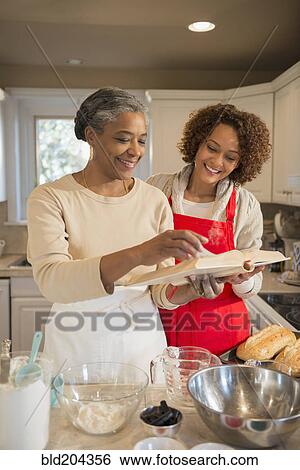 Mother and daughter baking in kitchen View Large Photo Image Stock Photograph - Mother and daughter baking in kitchen. Fotosearch