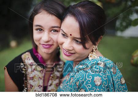 Stock Photo - Mother and daughter in Indian clothing hugging outdoors. Fotosearch