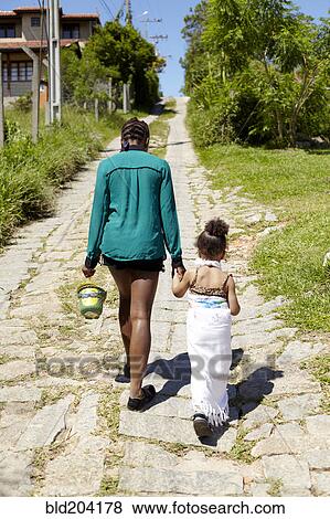 Stock Photo - Mother and daughter on cobblestone street. Fotosearch