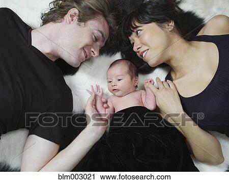 Stock Image - Mother and father bonding with newborn. Fotosearch
