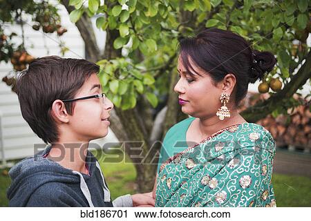 Stock Image - Mother and son talking in garden. Fotosearch