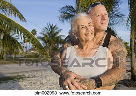 Mother and tattooed son hugging at the beach View Large Photo Image Stock Photo - Mother and tattooed son hugging at the beach. Fotosearch