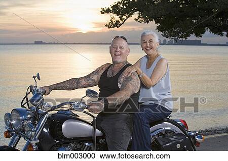 Mother and tattooed son riding motorcycle at the beach View Large Photo Image Stock Image - Mother and tattooed son riding motorcycle at the beach. Fotosearch